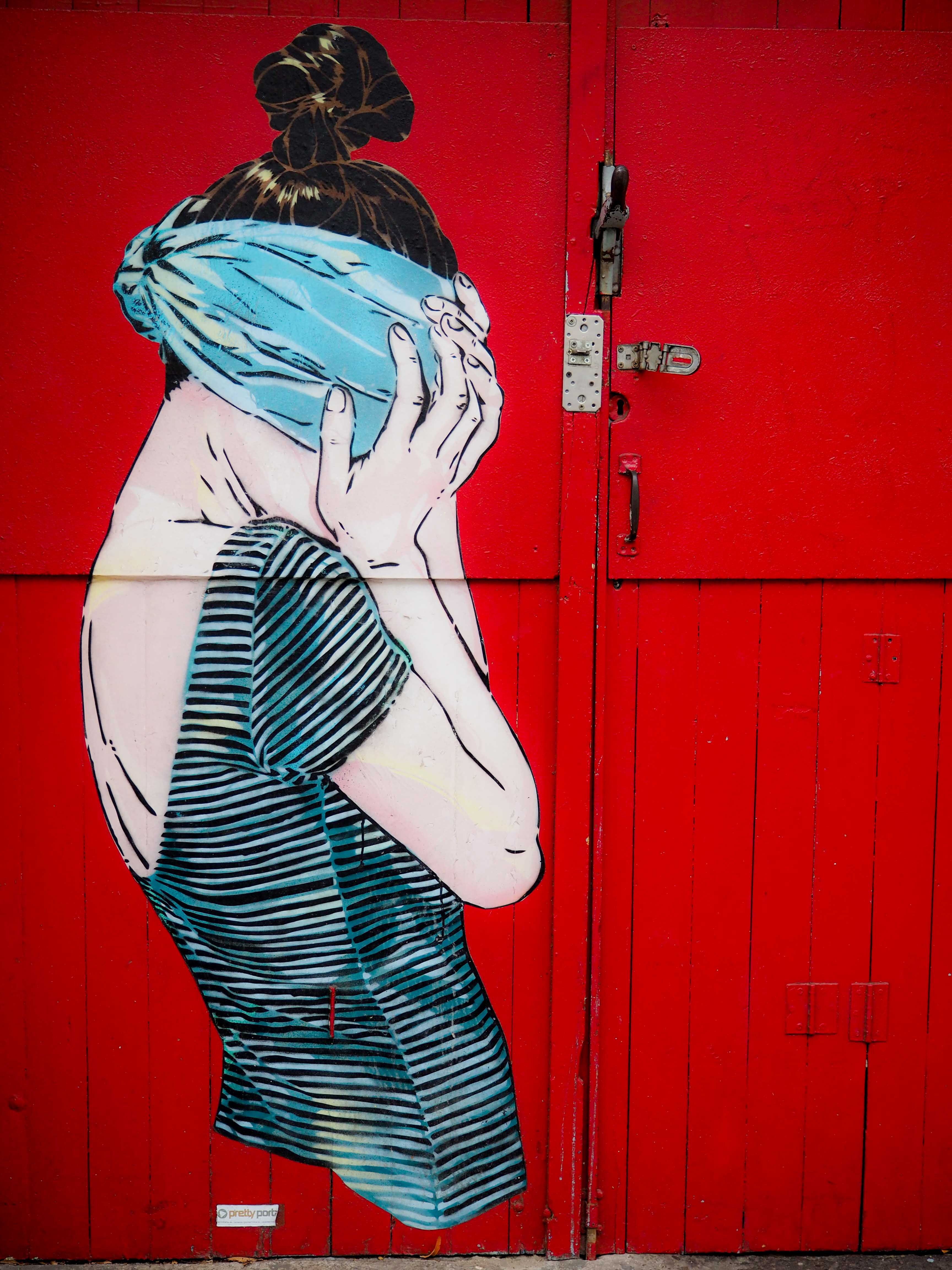 Jana und Js Mural zeigt eine Frau mit verbundenen Augen vor einer roten Wand