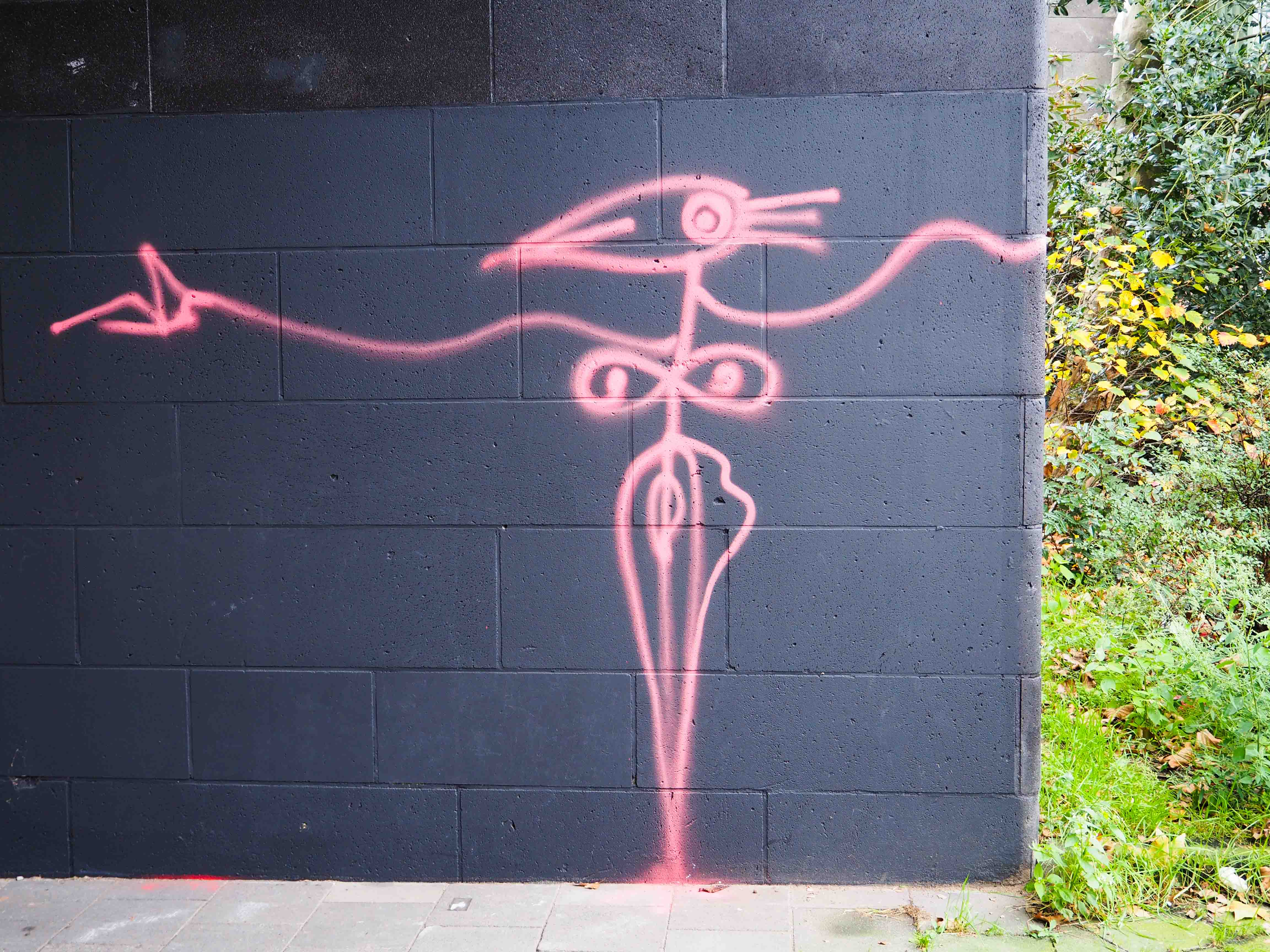 Harald Naegeli hat eine seiner typischen Figuren auf eine schwarze Wand eines Brückenpfeilers gesprüht