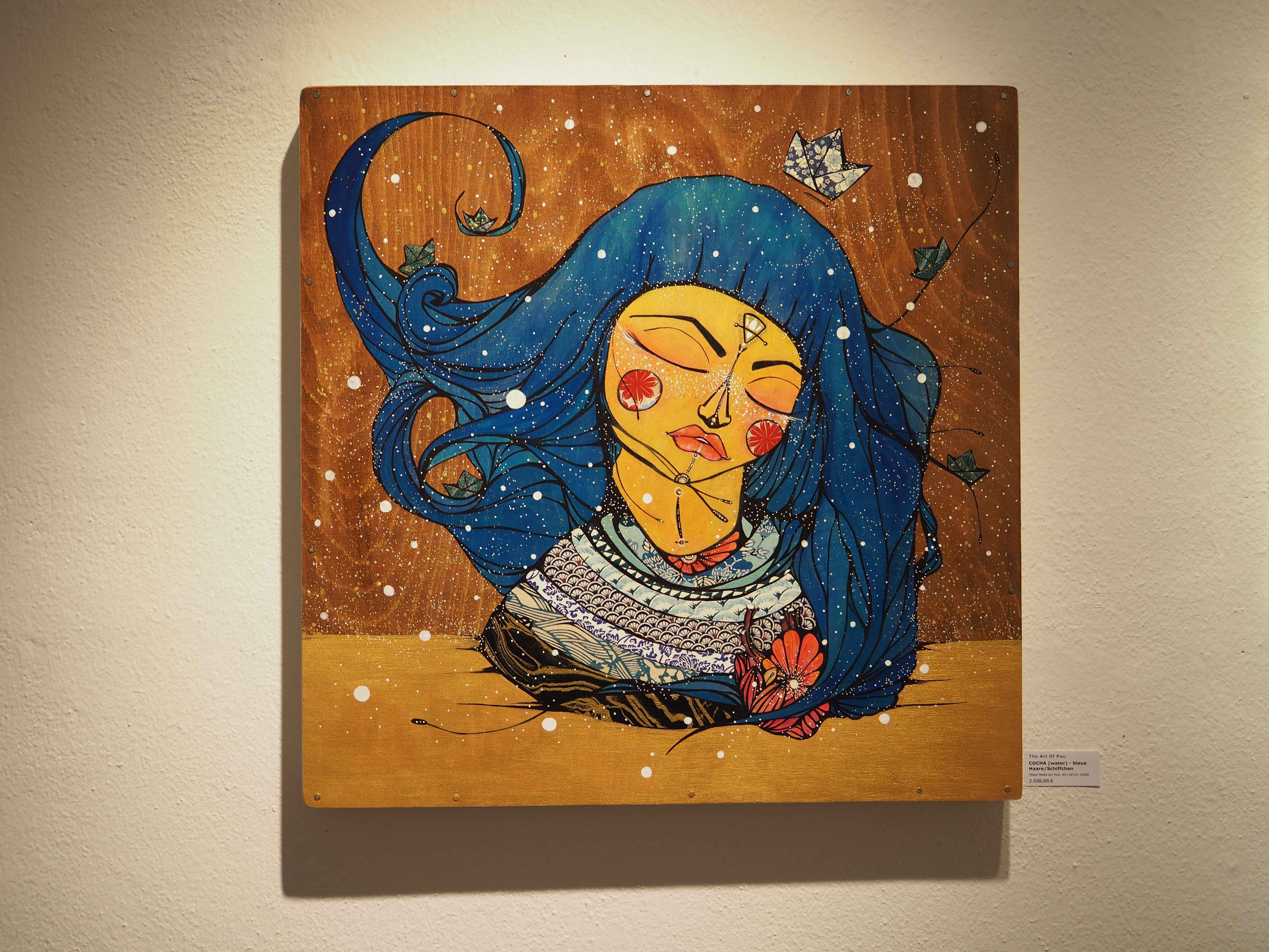 The Art of Pau zeigt eine Frau mit blauen Haaren auf einem Holzhintergrund
