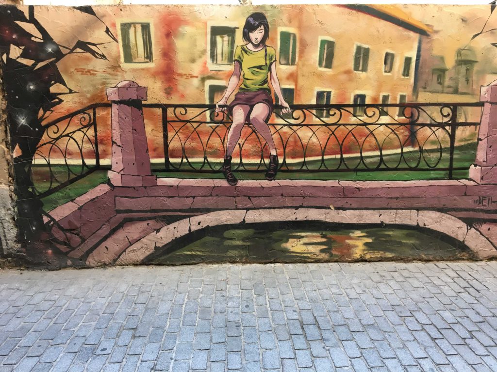 Deih malte ein Mural auf dem ein Mädchen zu sehen ist, das in Venedig auf einer Brücke sitzt