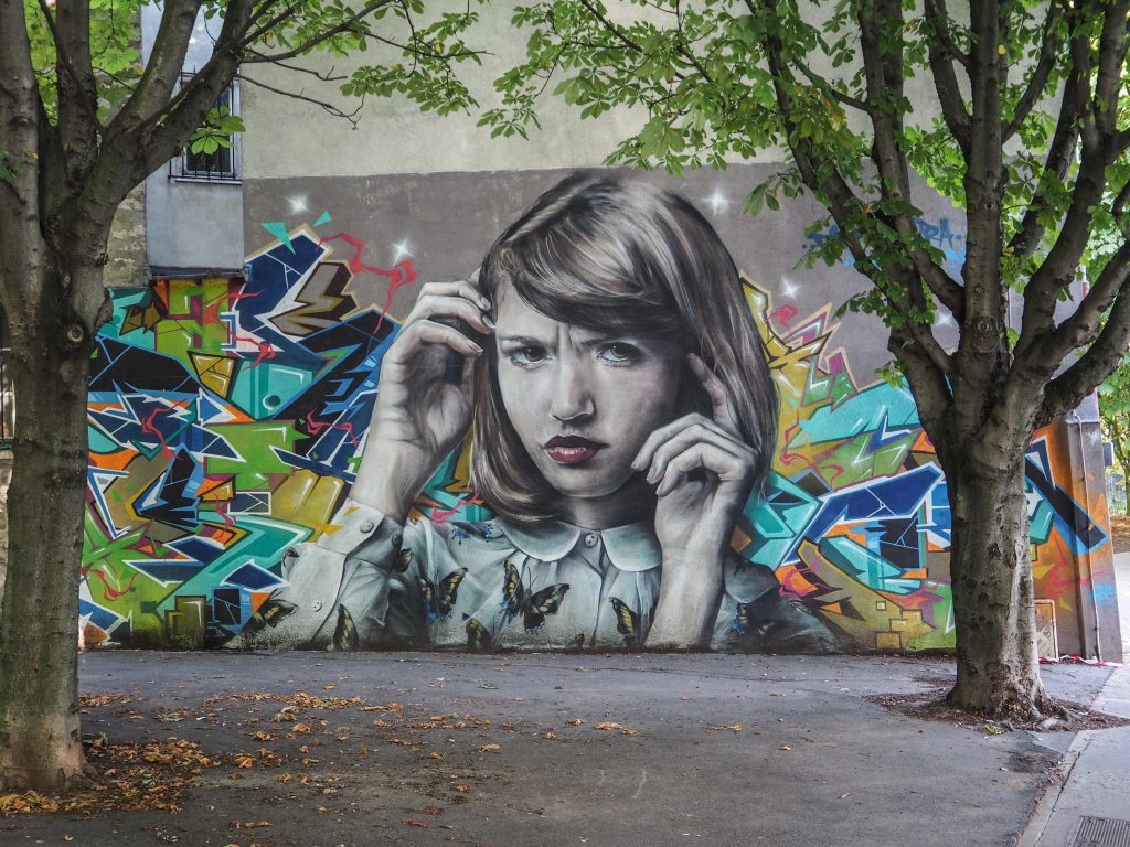 Portrai eines Mädchens von Mantra und Takt an einer Wand im Park
