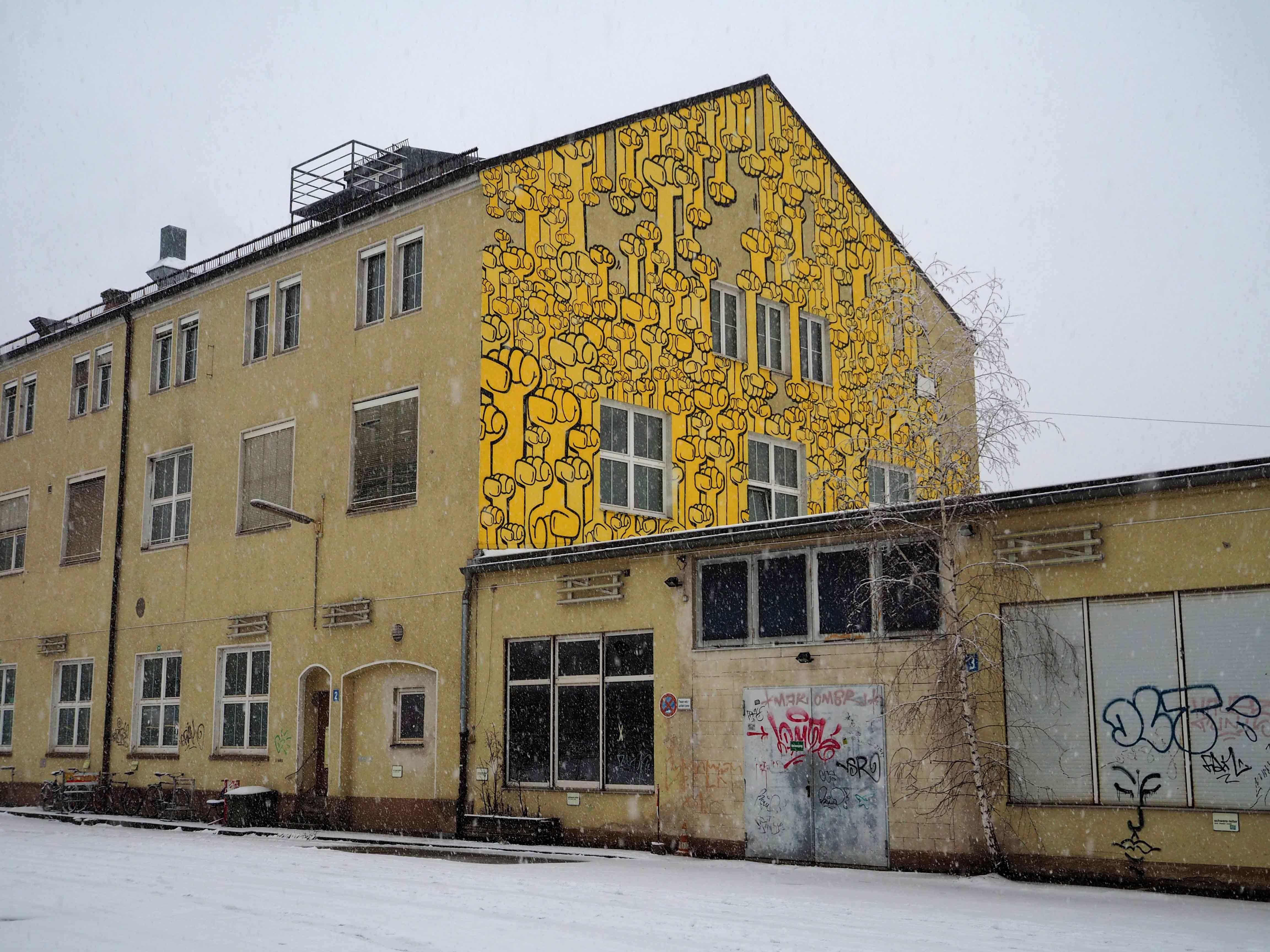 Das Mural von Kripoe zeigt lauter gelbe Fäuste die Für "Hände hoch für Waffenkontrolle" stehen