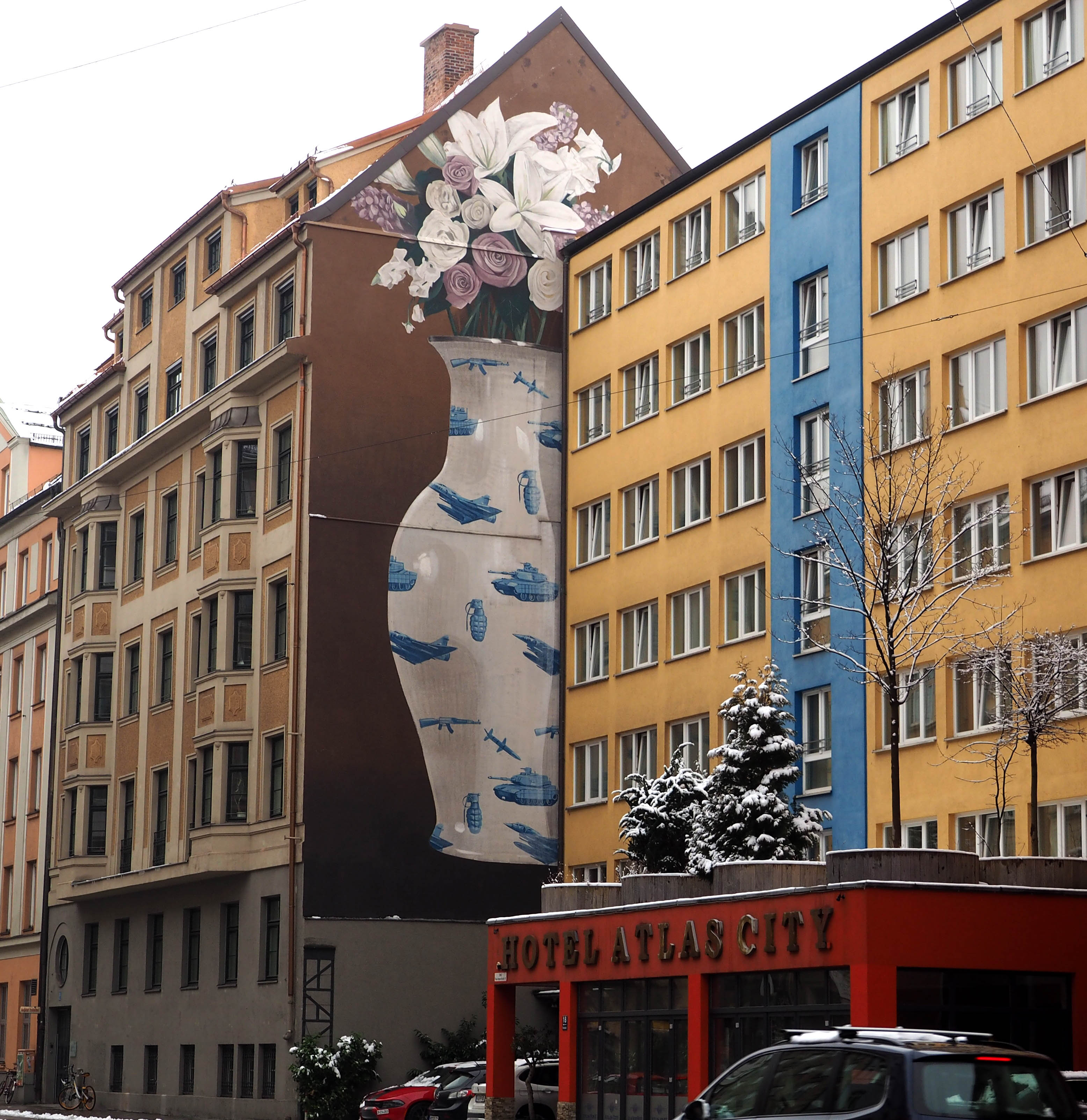 das mehrere Etagen hohe Mural von Escif zeigt eine Blumenvase mit Militärdesign