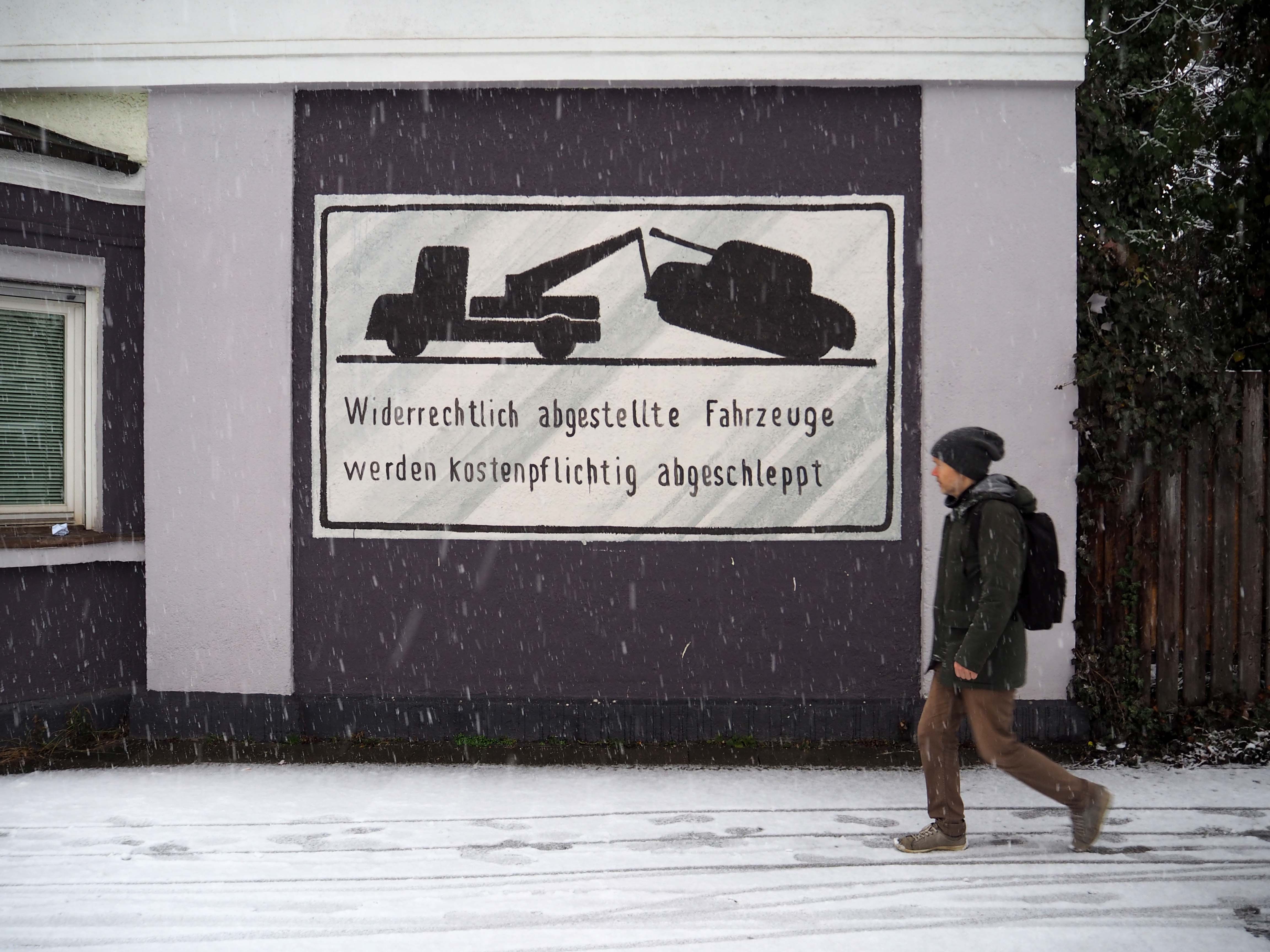 "Widerrechtlich abgestellte Fahrzeuge werden kostenpflichtig abgeschleppt" steht geschrieben und abgebildet ist ein Panzer der abgeschleppt wird