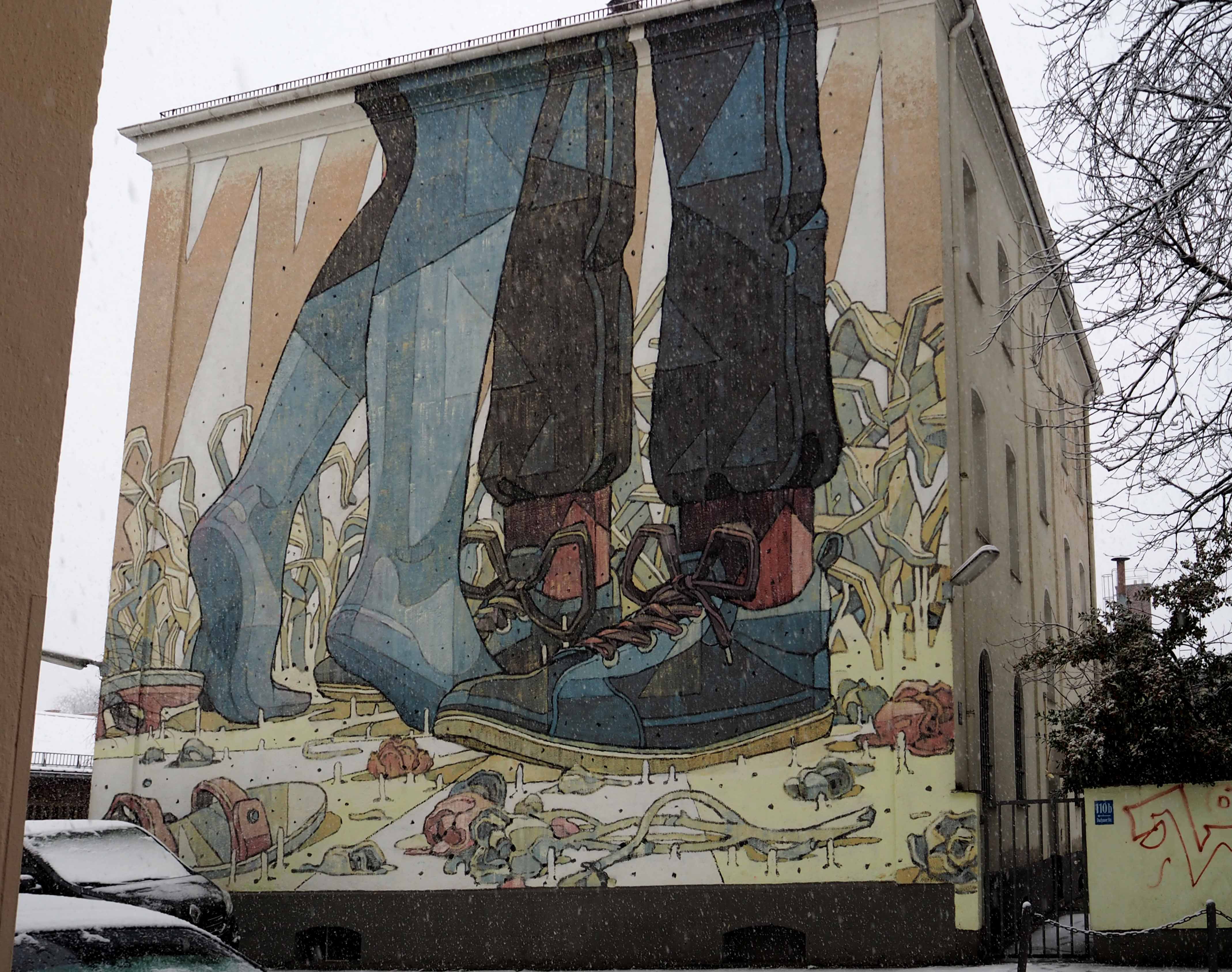 das Mural von Aryz zeigt die Beine eines Paares dass sich vermutlich umarmt