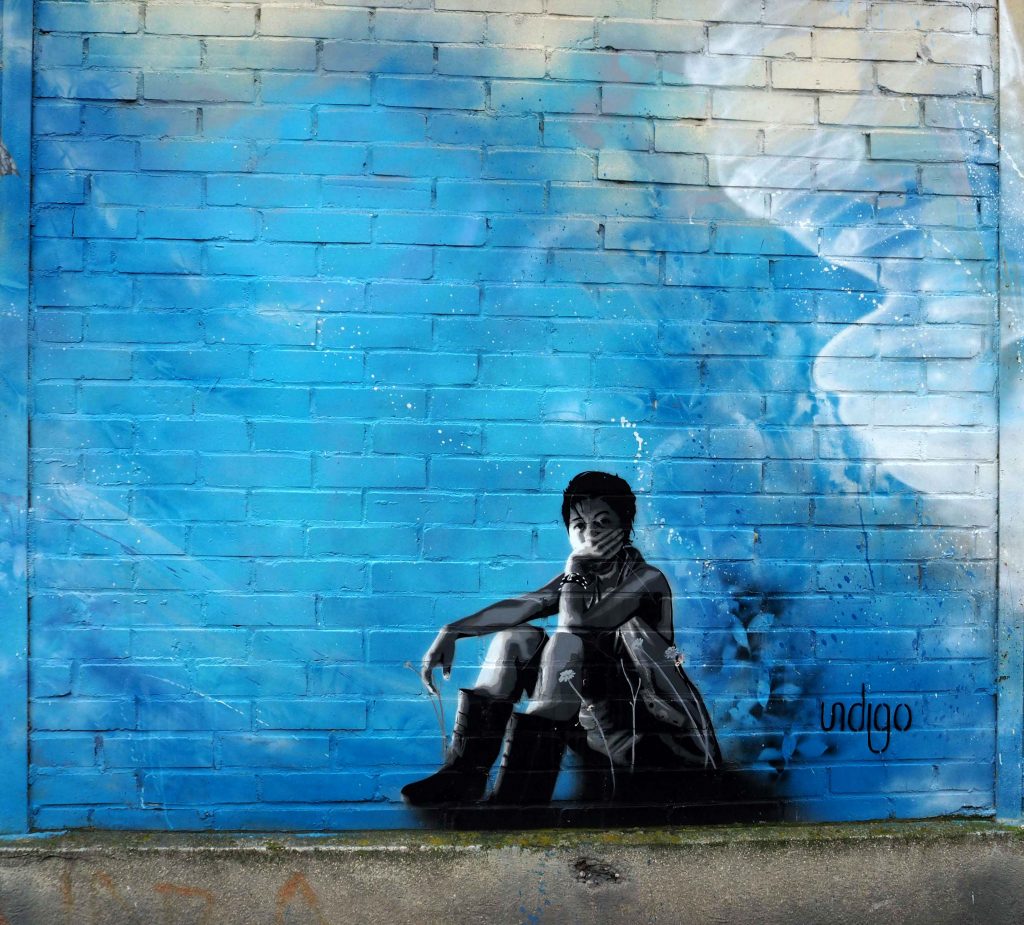 Muraldetail von Indigo zeigt eine junge sitzende Frau