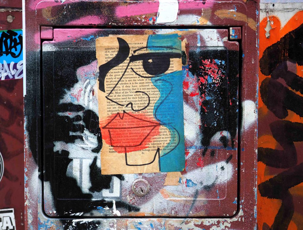 auf eine Buchseite wurde ein Gesicht gemalt und aufgeklebt