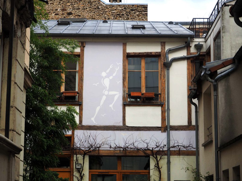 Jérôme Mesnager malt eine Figur in einem Hinterhof
