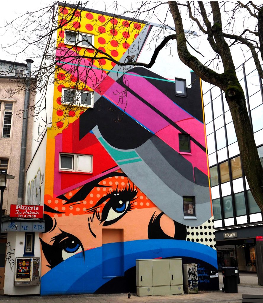 Ein Mural von Sen2 Wall2 mit einem Gesicht im Pop-Art Stil
