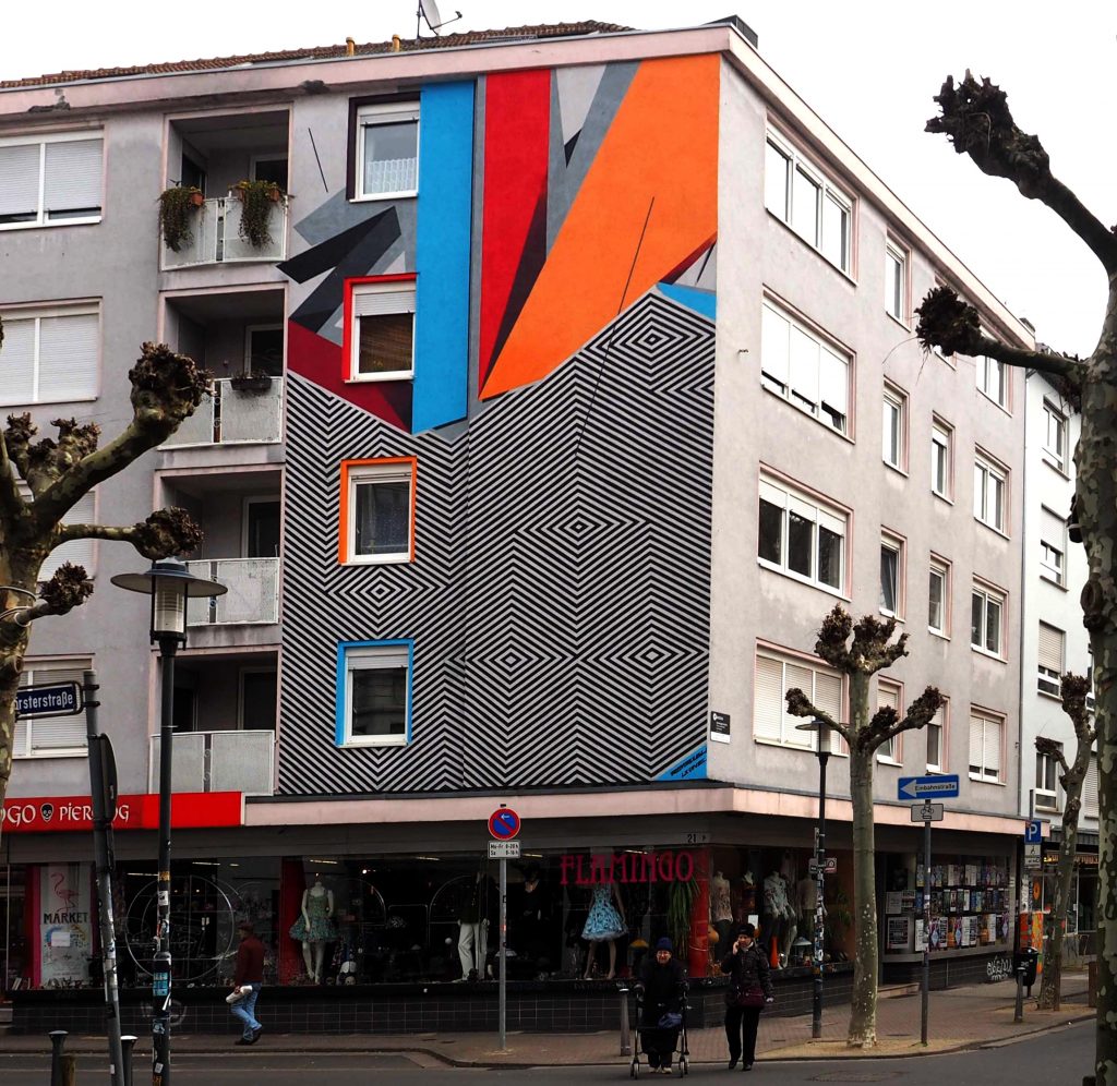 Mural zweigestaltig mit schwarz/weiß und bunten geometrischen Mustern