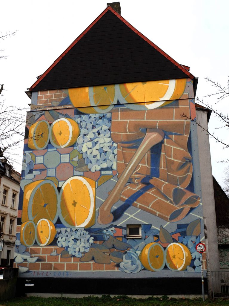 Mural von Aryz dass Orangen und Wände zeigt.