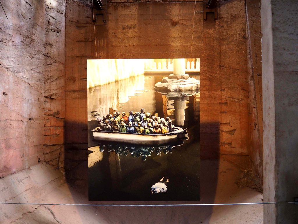 ein Foto zeigt ein überfülltes Rettungsboot und eine Leiche