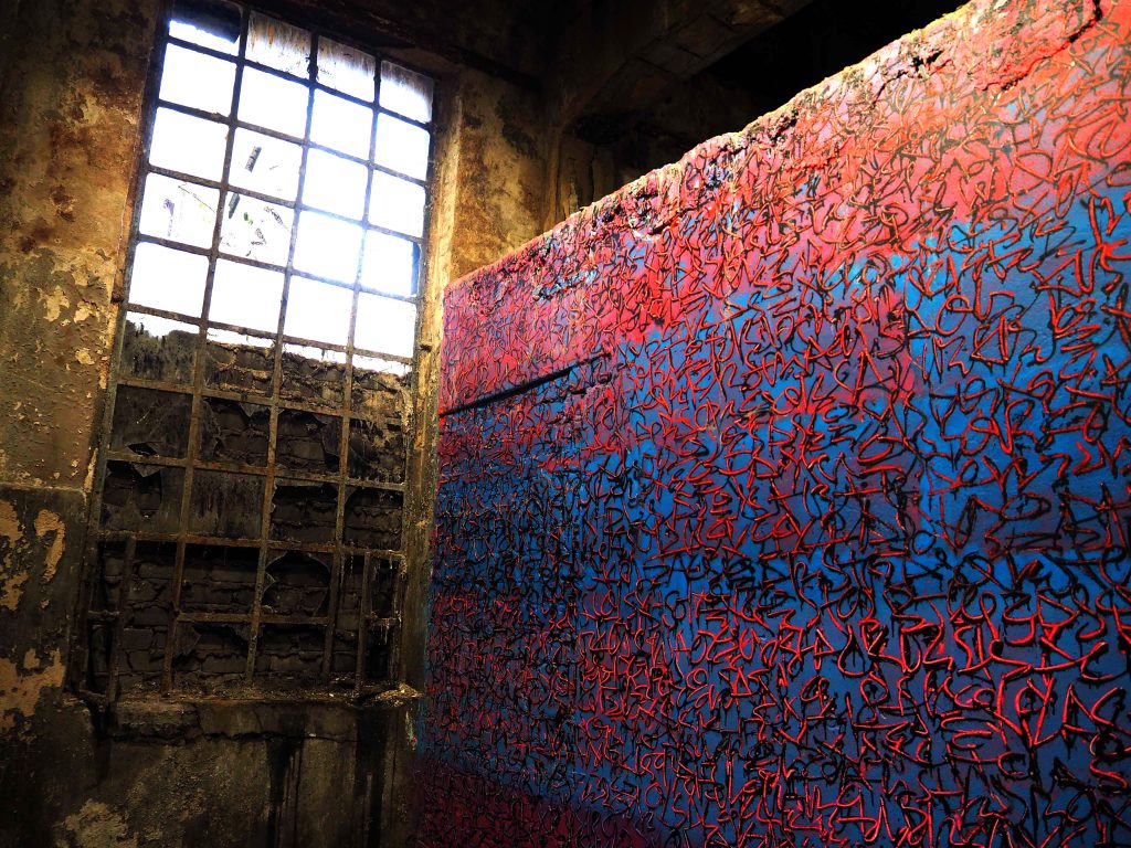 Detail von der Arbeit von Tanc auf dem eine getaggte Wand und ein Fenster zu sehen sind.