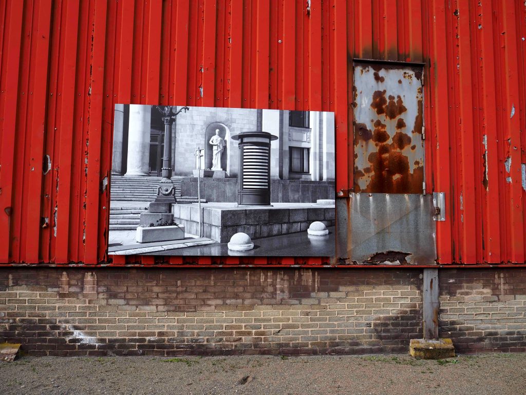 Auf rotem Hintergrund hängt ein Foto von Jordan Seiler.