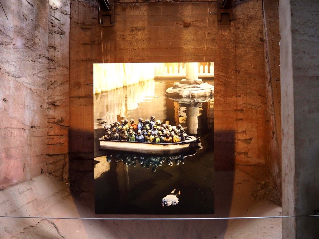 ein Foto zeigt ein überfülltes Rettungsboot und eine Leiche