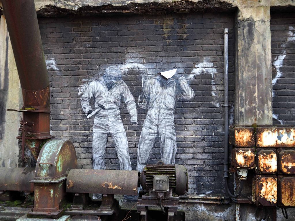 Zwei Arbeiter ohne Körper, nur mit Kleidung und Werkzeug von Levalet