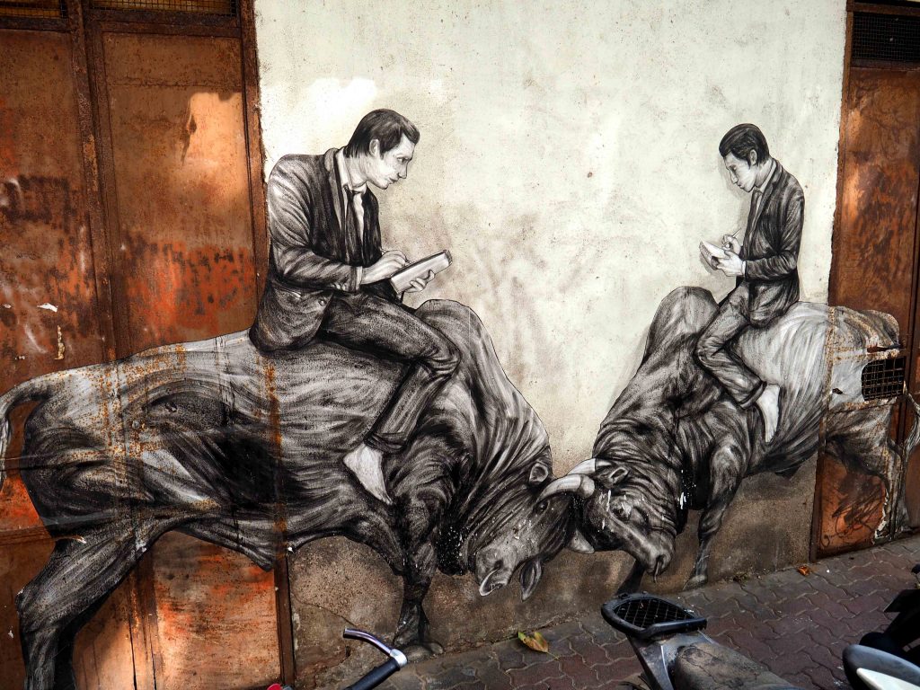 Zwei Männer sitzen auf Stieren und lesen dabei