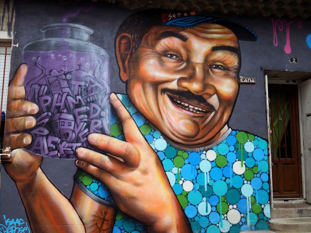 Mann hält ein Glas mit Buchstaben darin