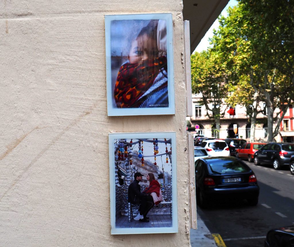 Fotos im Rahmen auf Hauswand geklebt