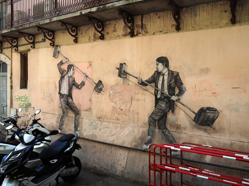 Zwei Männer im Anzug kämpfen mit Hanteln