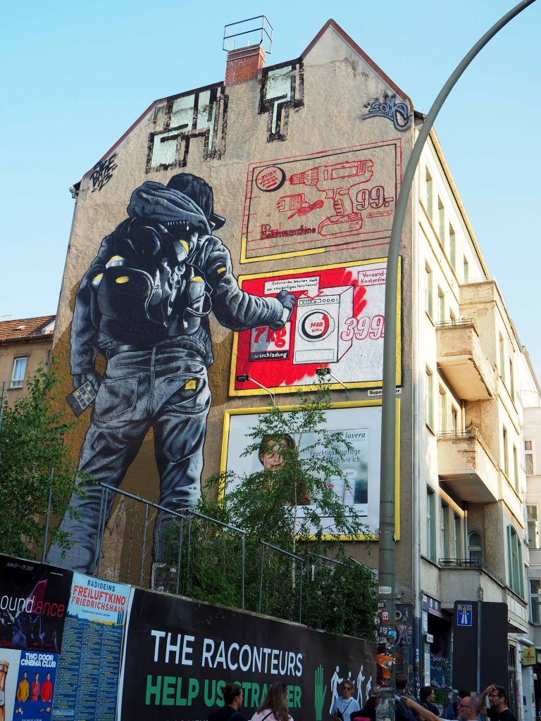 Graffitisprayer übermalt Werbung